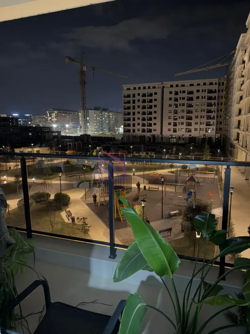 View from the balcony of the illuminated courtyard and surrounding buildings at night.