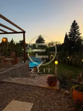 Pogled na uređeno dvorište sa bazenom i terasom u sumrak. - image 56