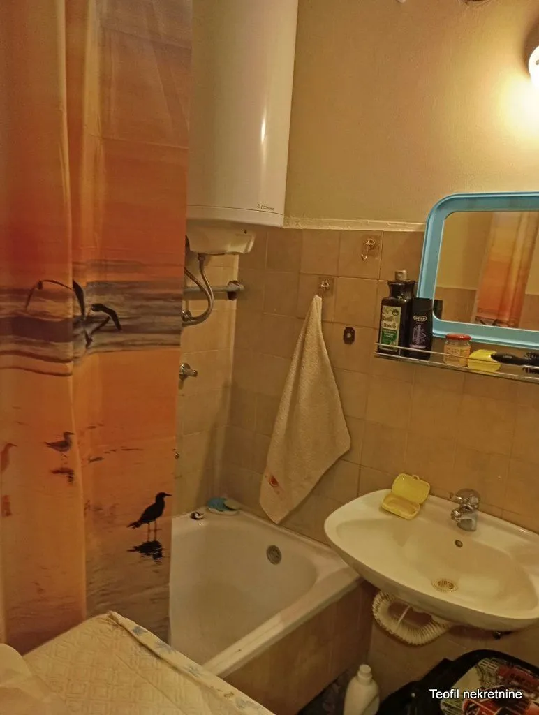 Small bathroom with a bathtub, washbasin, and water heater.