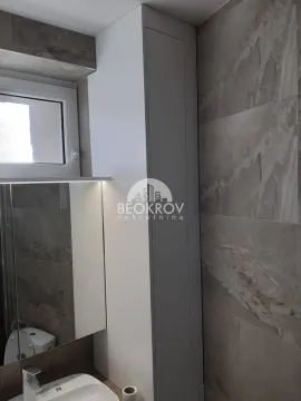 Moderno opremljeno kupatilo sa umivaonikom, ogledalom i pločicama u sivoj boji. - image 12