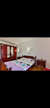 Furnished bedroom with a double bed and a wooden wardrobe. - image 4