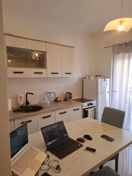 Small kitchen with a dining table and light-toned kitchen cabinetry. - image 4