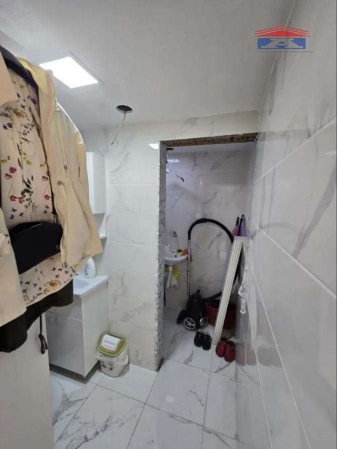 Small bathroom tiled with ceramic tiles and equipped with a sink.