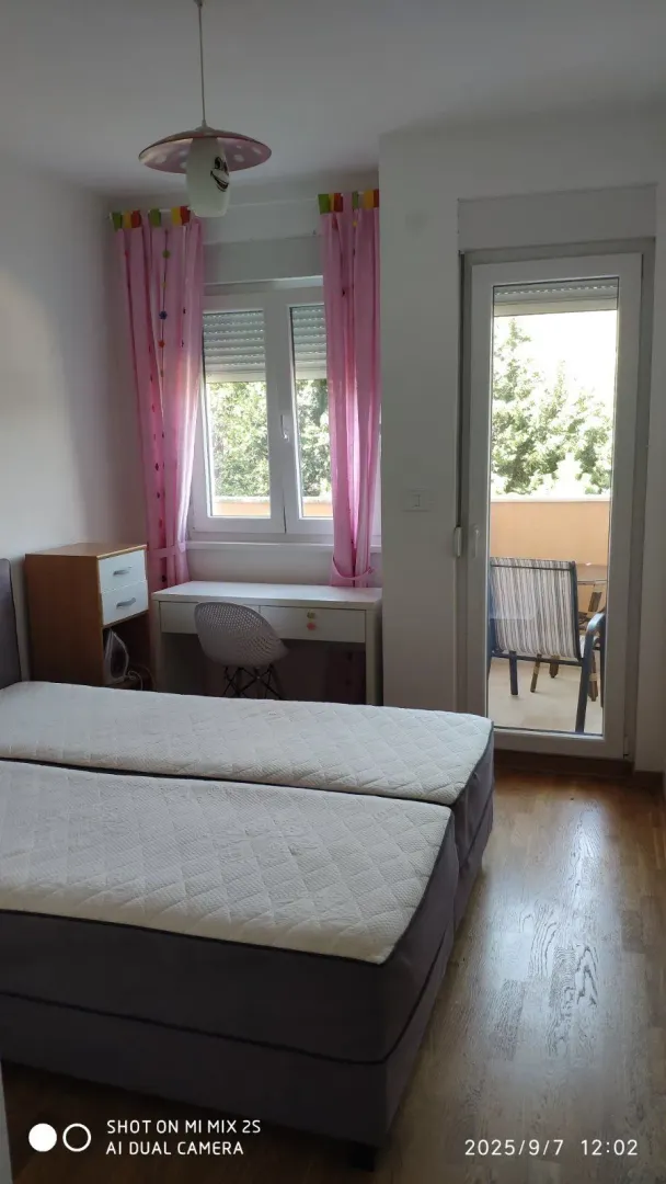 Bright bedroom with a desk and access to a balcony.
