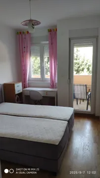 Bright bedroom with a desk and access to a balcony. - image 2