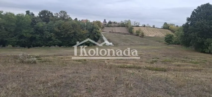 Pogled na prostrano zemljište sa zelenilom i okolnim pejzažem.