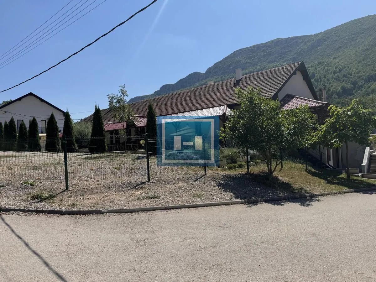 View of the exterior of the house with a yard and surrounding mountains in the background.