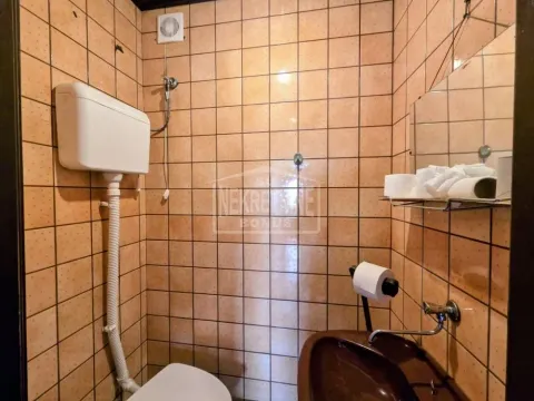Manje kupatilo obloženo keramičkim pločicama u braon tonovima sa umivaonikom i wc šoljom. - image 13