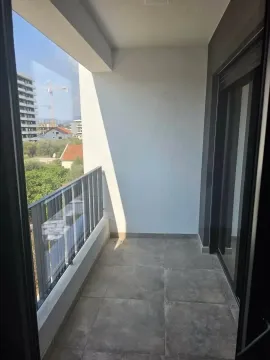 Prazna natkrivena terasa sa keramičkim pločicama i pogledom na grad. - image 7