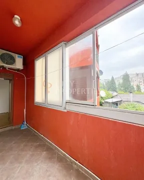 Covered balcony with tiled flooring and glass windows. - image 3