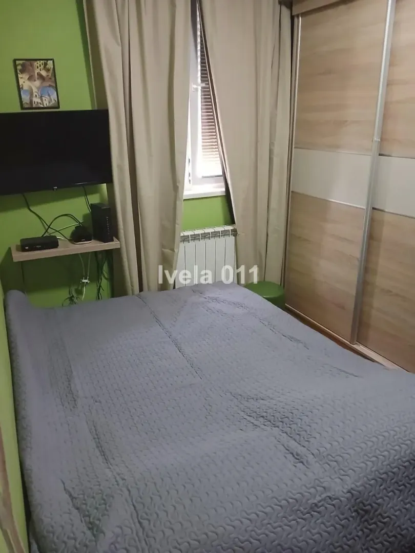 Spavaća soba sa bračnim krevetom, plakarom i televizorom.