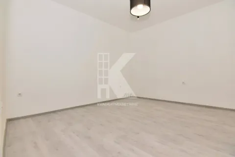 Empty room with white walls, light laminate flooring, and a ceiling light fixture. - image 6