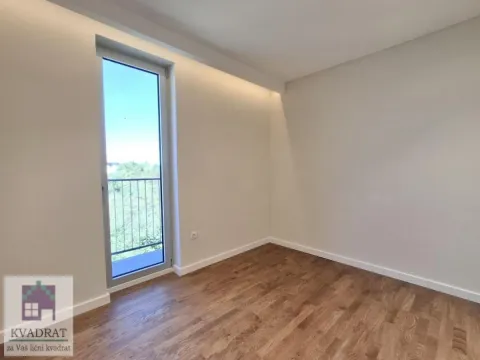 Prazna soba sa drvenim podom i izlazom na balkon. - image 9