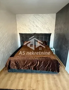Spavaća soba sa bračnim krevetom i dekorativnim zidom. - image 11