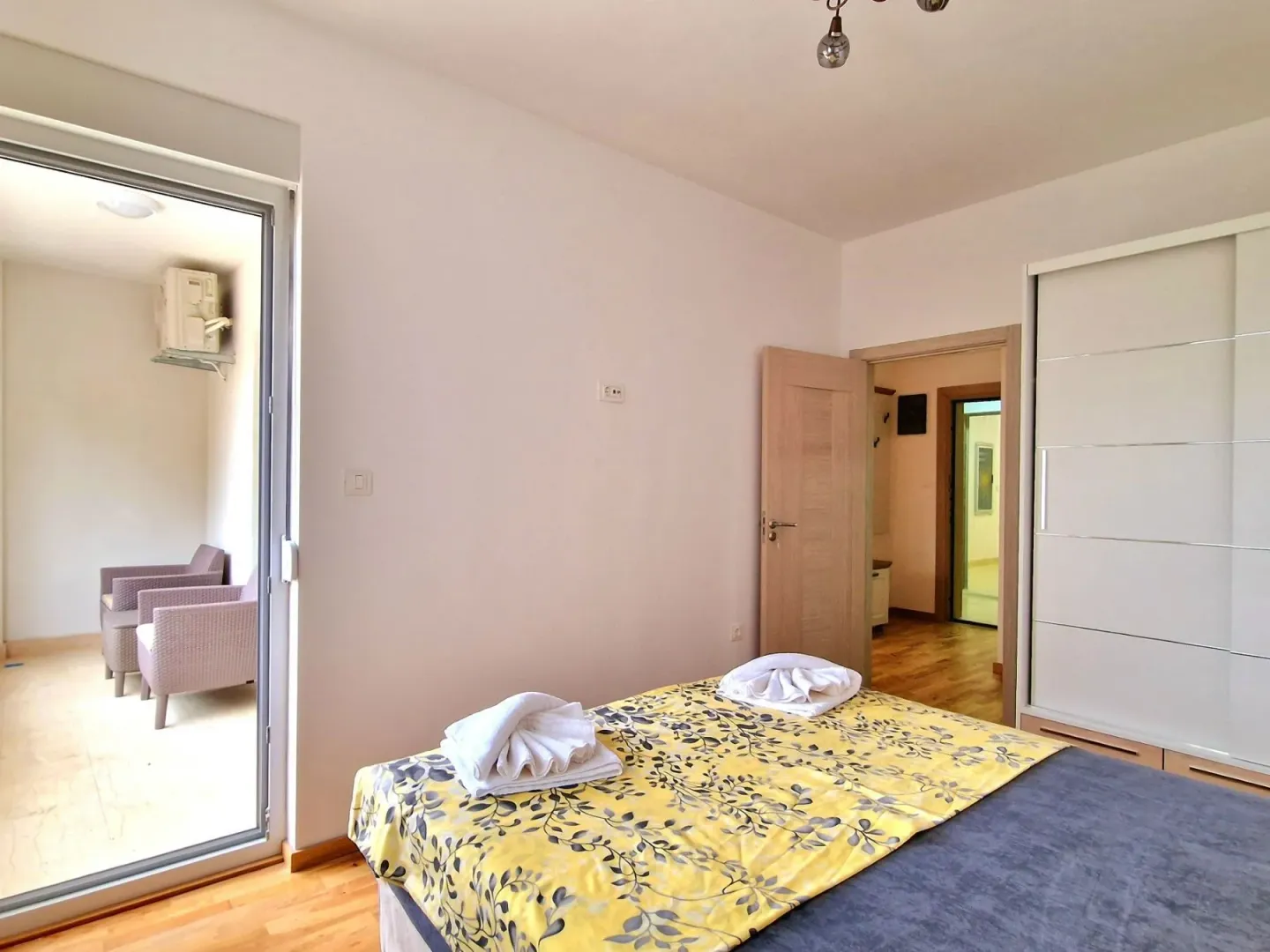 Bedroom with a double bed, wardrobe and access to the terrace.