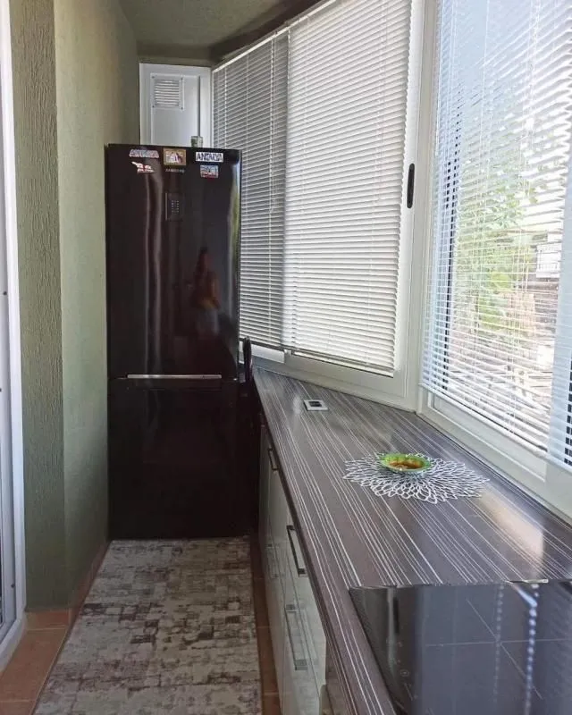Manja kuhinja sa dugim radnim dijelom i frižiderom.