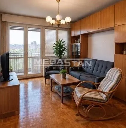 Living room with sofa, armchair and access to the balcony.