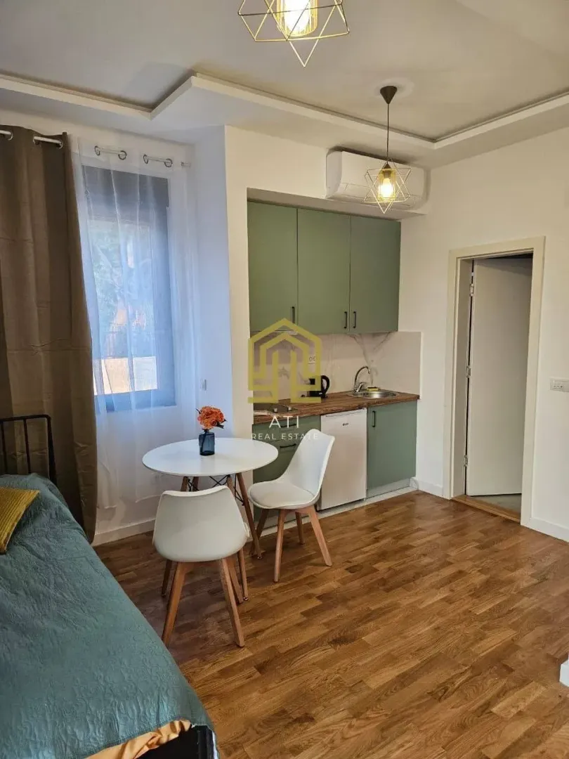 Manja kuhinja sa trpezarijskim stolom i stolicama u sklopu prostorije.
