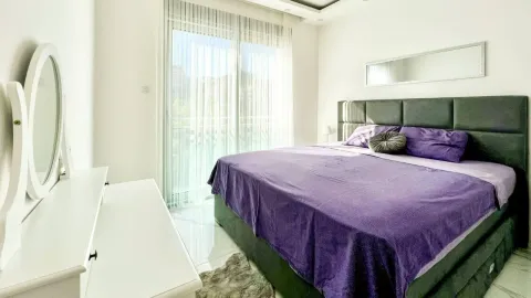 Spacious bedroom with a large double bed, white furniture, and access to the terrace. - image 6