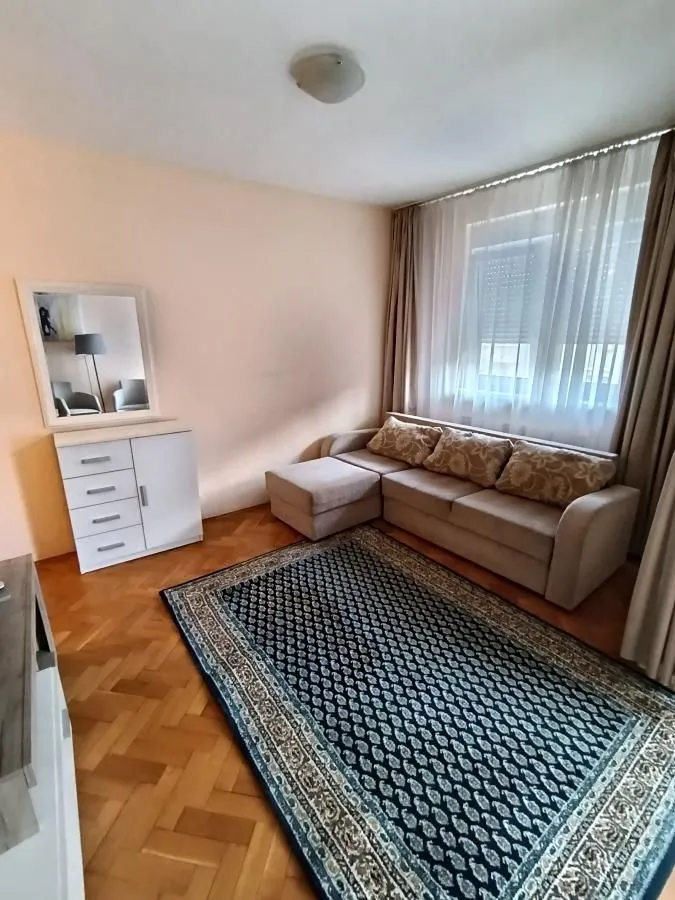 Living room with a sectional sofa, chest of drawers, and a mirror.