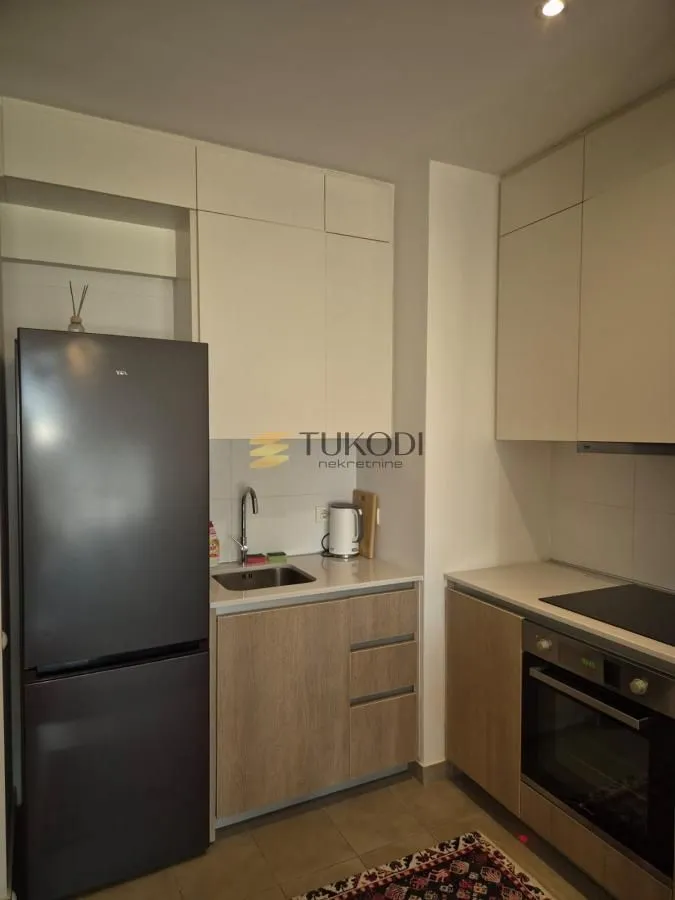 Kitchen equipped with cabinetry, built-in oven, and a refrigerator.