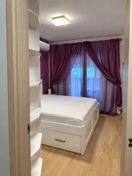 Pogled iz hodnika na spavaću sobu sa bijelim krevetom i ljubičastim zavjesama. - image 5
