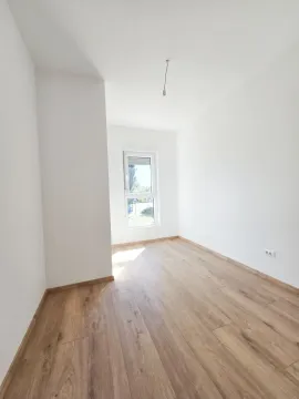 Prazna soba sa bijelim zidovima i drvenim podom. - image 4