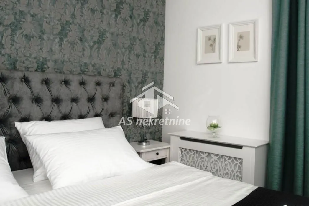 Bedroom with a double bed and patterned wallpaper.