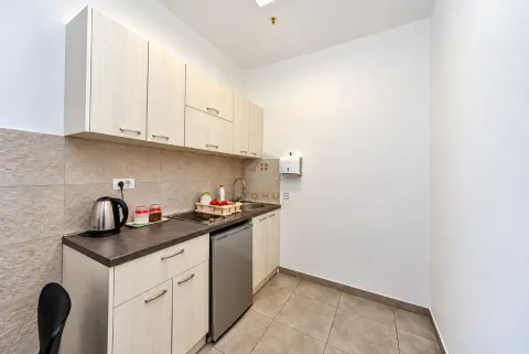Small kitchenette with white cabinets and a built-in refrigerator. - image 5