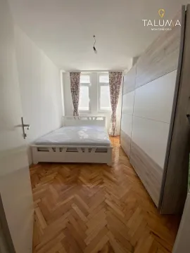 Furnished bedroom with a double bed, large wardrobe, and parquet flooring. - image 4