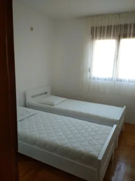 Spavaća soba sa dva odvojena kreveta i prozorom sa zavjesama. - image 6