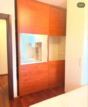 Bedroom with a large wooden wardrobe and a bed. - image 9