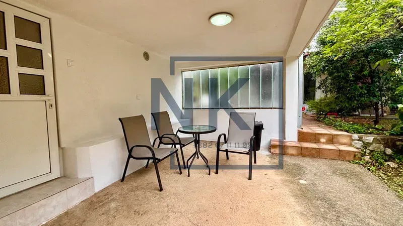 Covered terrace with patio furniture in front of the property entrance.