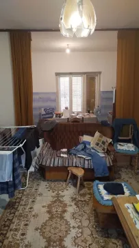 Living room with a sofa and a dining table in the background. - image 2