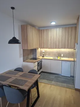Moderna kuhinja sa drvenim elementima i trpezarijskim stolom. - image 9