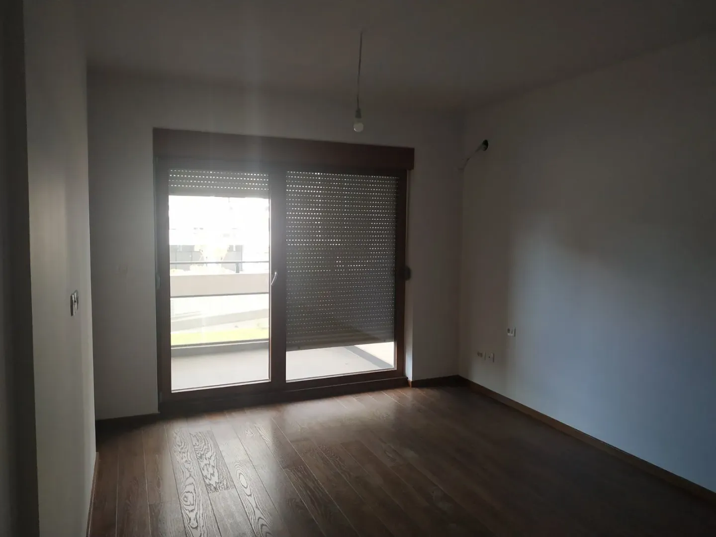 Prazna i neuseljena soba sa izlazom na terasu.