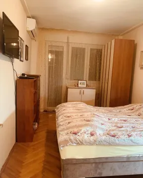 A bedroom with a double bed, wooden furniture, and a wall-mounted TV. - image 7