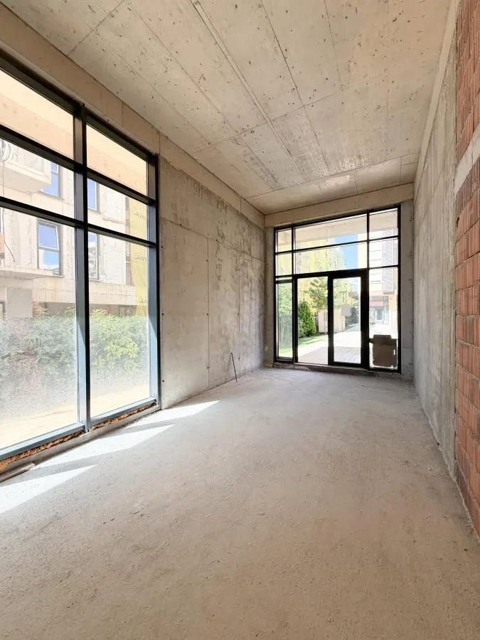 View of an empty room in grey phase construction with large glass surfaces.