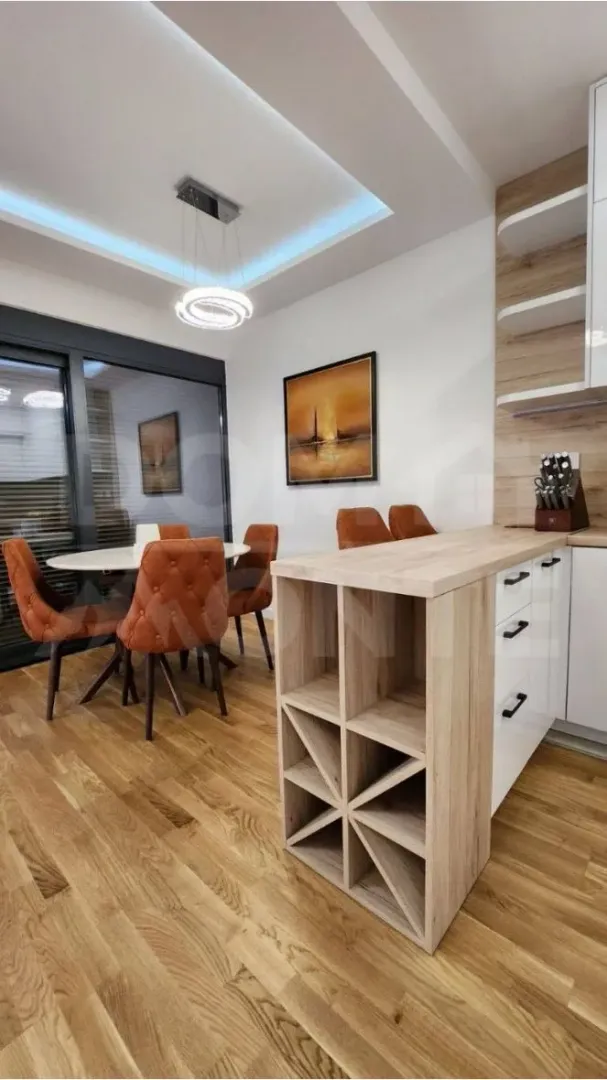 Modern kitchen with wooden elements and a dining area.