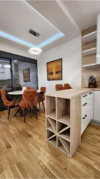 Modern kitchen with wooden elements and a dining area. - image 3