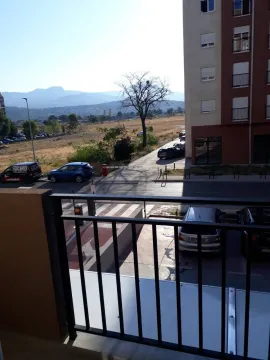 View from the balcony overlooking the street, parking lot, and surrounding mountains. - image 3