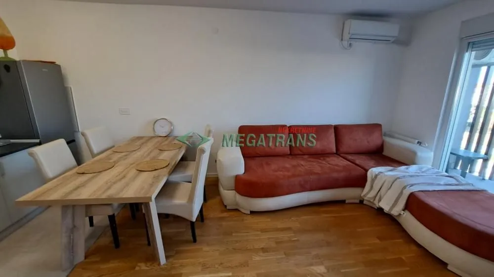 Dnevni boravak sa garniturom i trpezarijskim stolom.