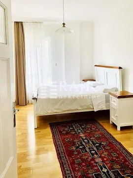 Bright bedroom with a double bed, bedside tables, and wooden flooring. - image 3