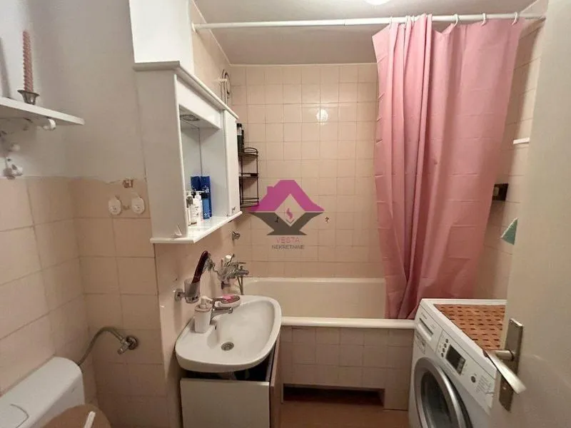 Manje kupatilo sa kadom, umivaonikom i veš mašinom.