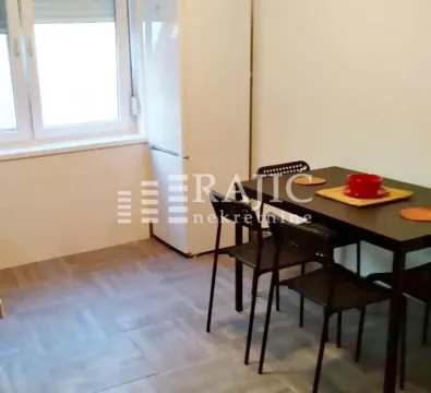 Dining area with a table, chairs, and refrigerator. - image 9
