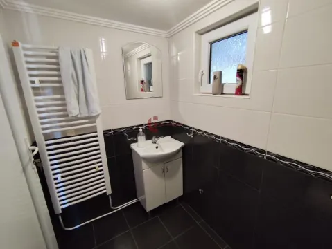 Bathroom with a sink, mirror, towel radiator, and a window. - image 13