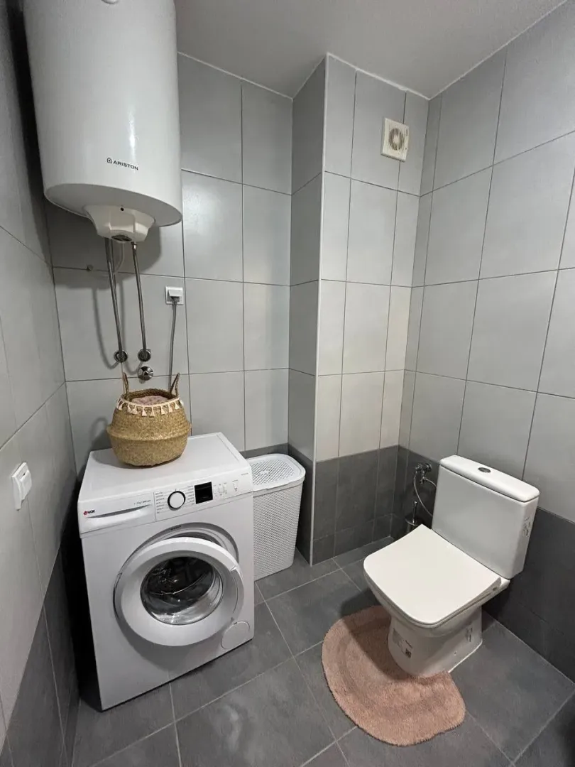 Kupatilo opremljeno sa wc šoljom, veš mašinom i bojlerom.