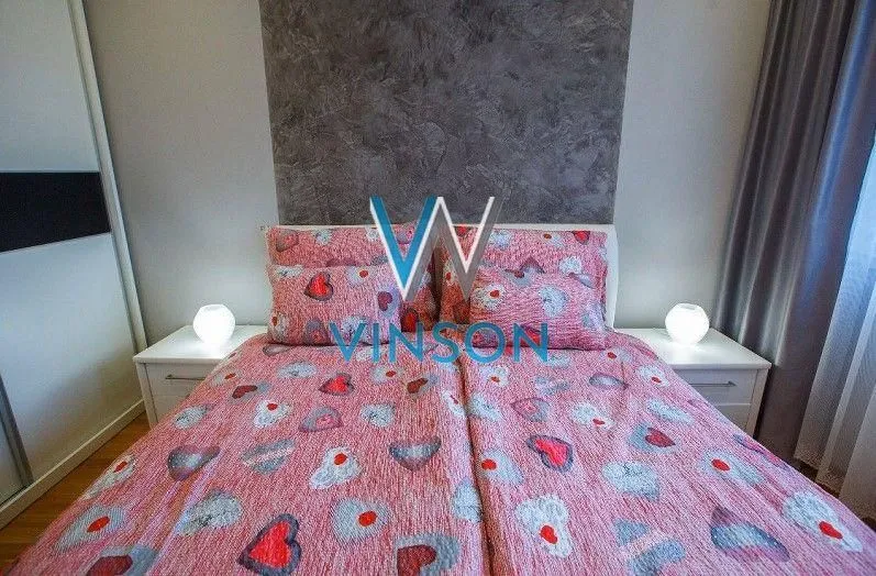 Spavaća soba sa bračnim krevetom i noćnim stočićima sa lampama.