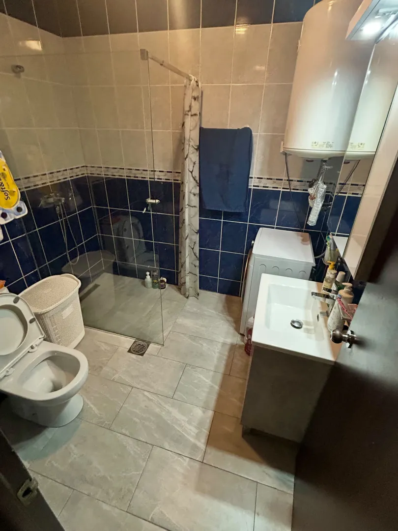 Kupatilo opremljeno tuš kabinom, umivaonikom, wc šoljom i veš mašinom.