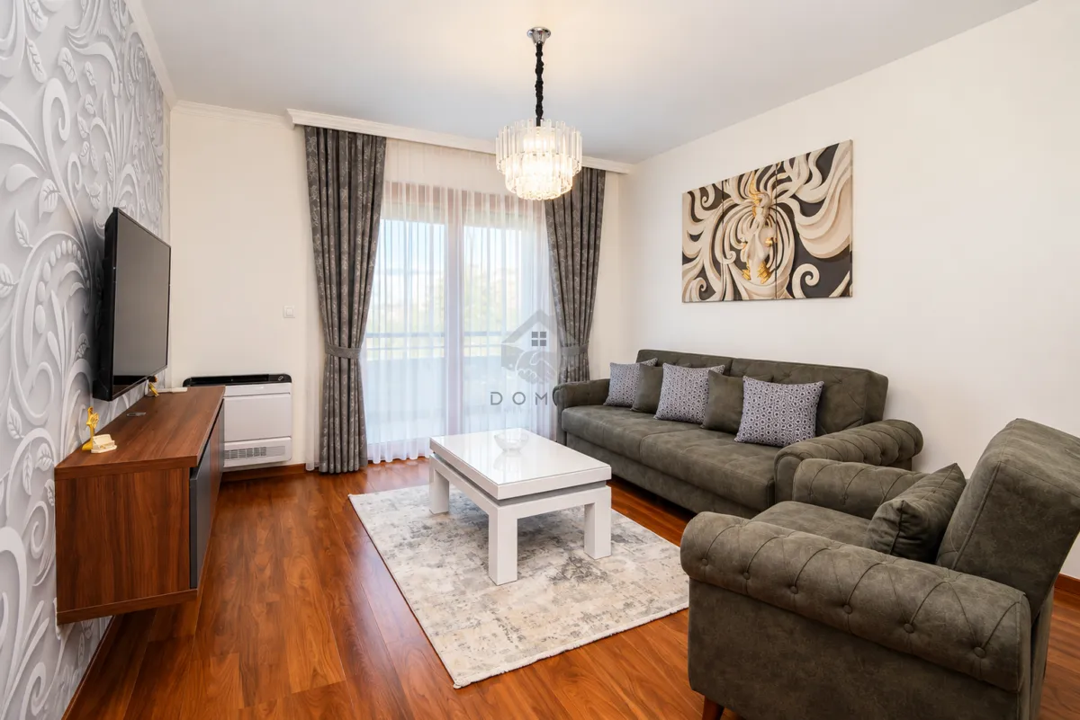 Living room with a sofa set, TV, and access to the terrace.